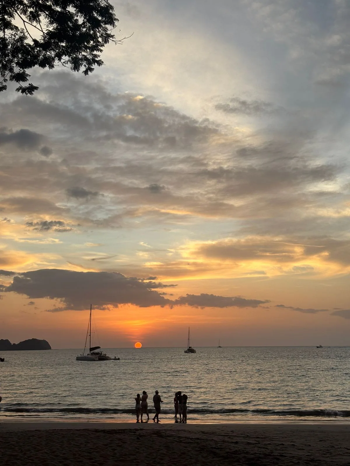 Visitors and sailboats at sunset in Guanacaste, Costa Rica